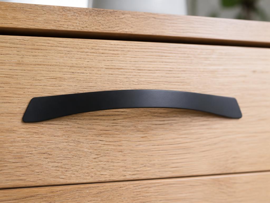 DH026BL matt black bow pull fitted to a light oak drawer front